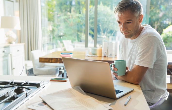 Middle aged male reviews 2-year fixed annuity rates on laptop