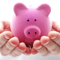 Pink piggy bank in hands