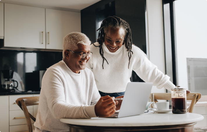 Older couple looking at their laptop, reviewing annuity rates