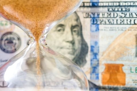 Hourglass in front of money