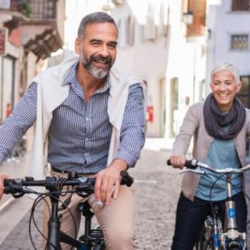 Retired couple exploring city on bicycles