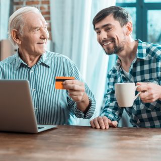 Son sitting next to Father holding a credit card