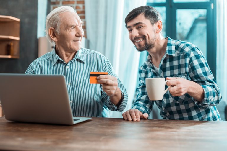 Son sitting next to Father holding a credit card