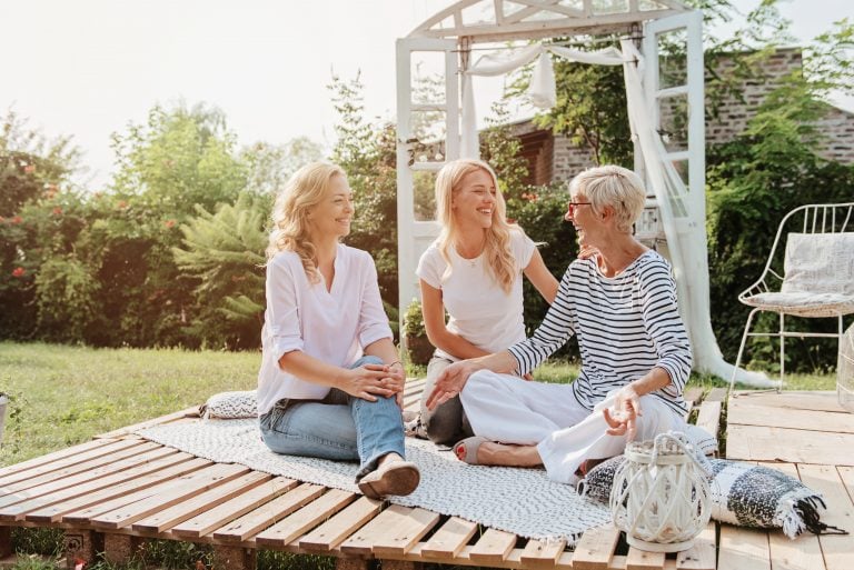 Three women outdoors talking and laughing