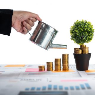 Woman watering coins and money growing