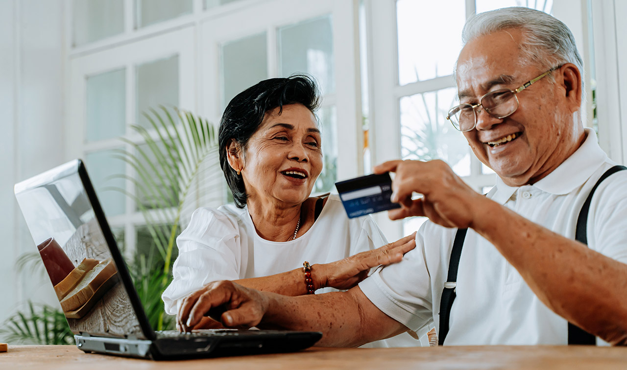 Happy Asian couple shopping online together