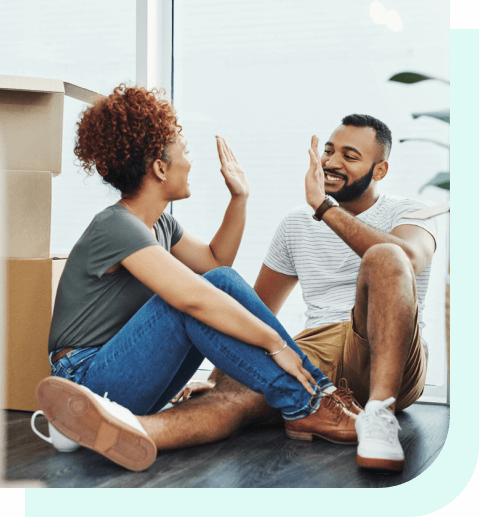 Couple high-fiving near moving boxes