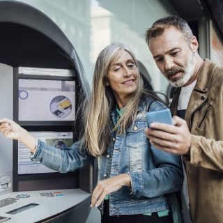 Portrait of a mature couple using their bank ATM.