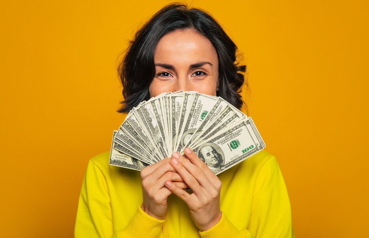 Happy woman, fanning 100 dollar bills