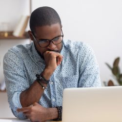 Worried man looking at laptop