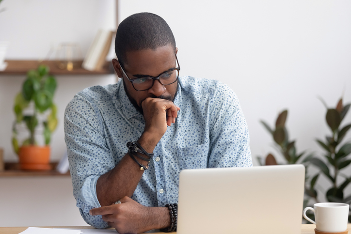 Worried man looking at laptop