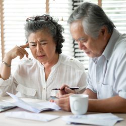 Senior couple looking at papers and laptop