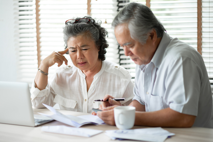 Senior couple looking at papers and laptop