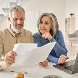 Couple looking at papers and laptop