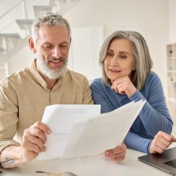 Couple looking at papers and laptop