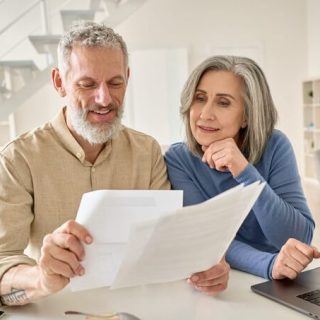 Couple looking at papers and laptop