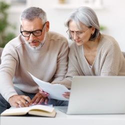 Couple working on taxes with laptop and papers