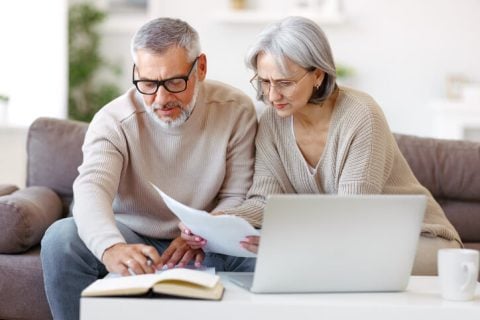 Couple working on taxes with laptop and papers