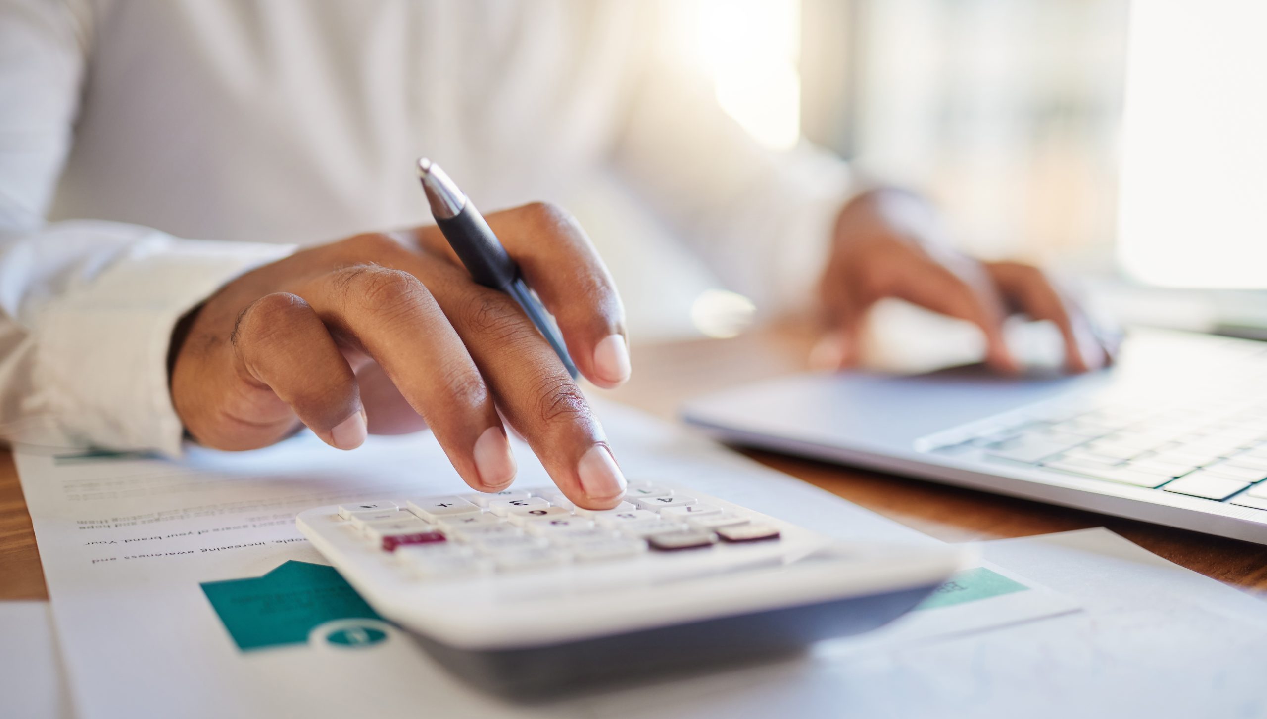 person using a calculator to review investments