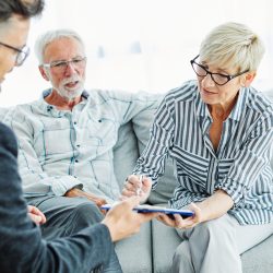 Happy senior old family couple clients make financial insurance estate business deal contract signing, agent lawyer, satisfied mature customers signing contract meeting bank manager agree on investment contract