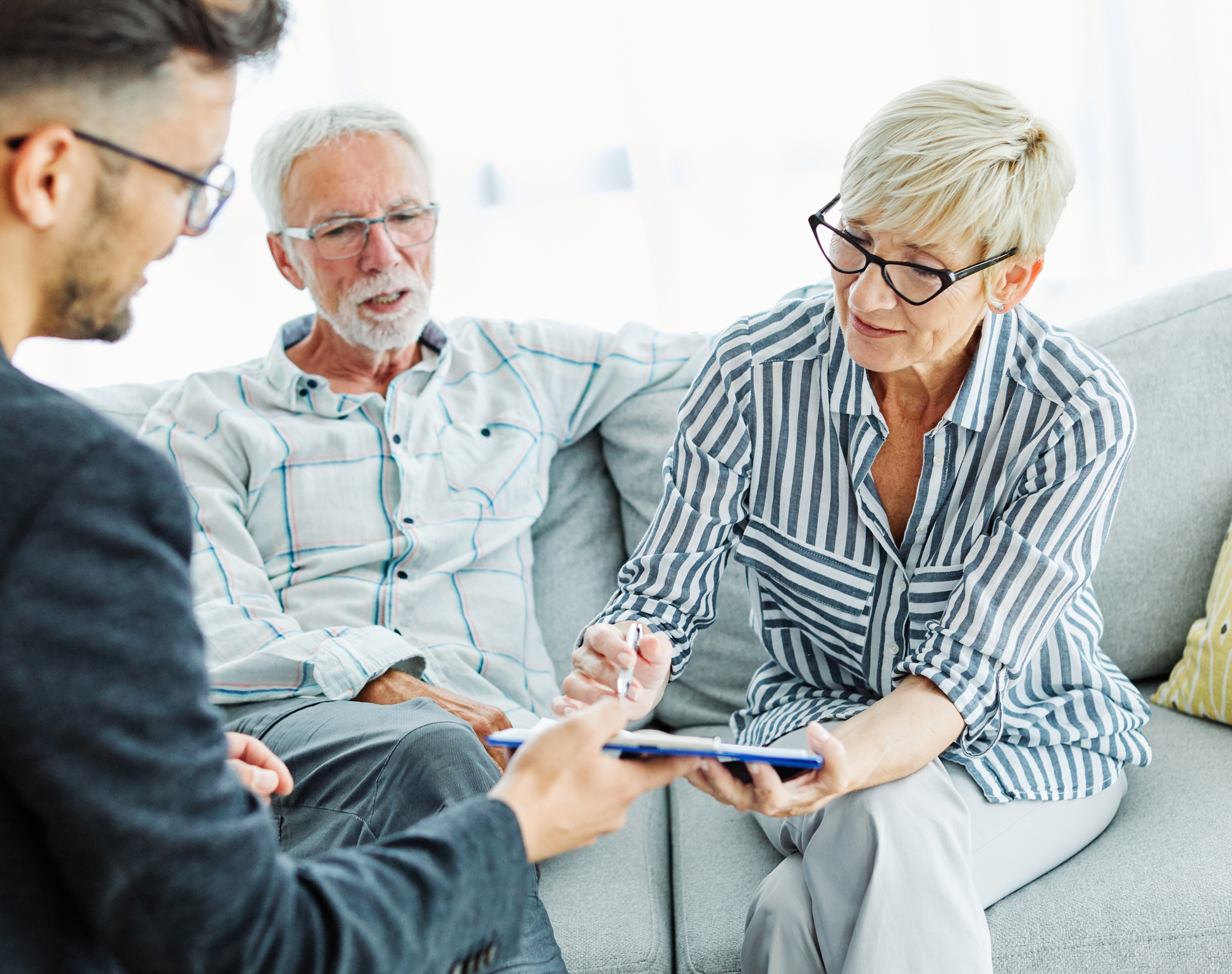 Happy senior old family couple clients make financial insurance estate business deal contract signing, agent lawyer, satisfied mature customers signing contract meeting bank manager agree on investment contract
