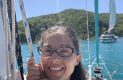Woman smiling on a boat while holding the sail