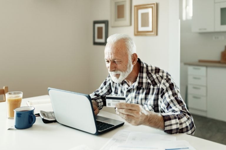 Senior Man using credit card and laptop