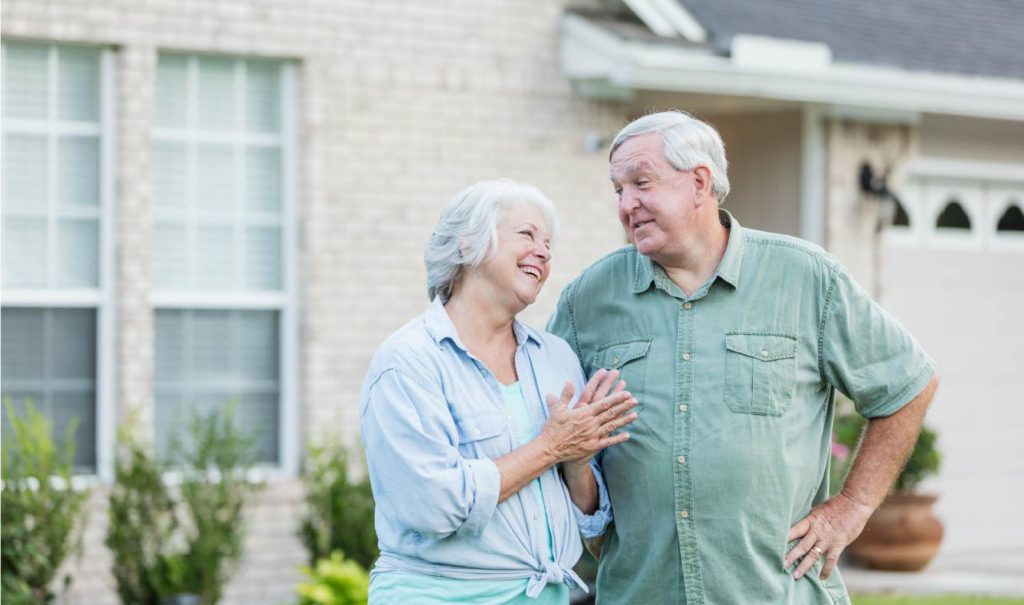 older couple in front of house