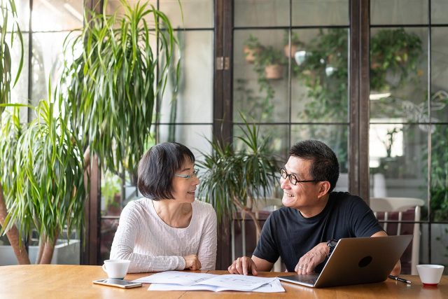 Older couple smiling and reviewing finances