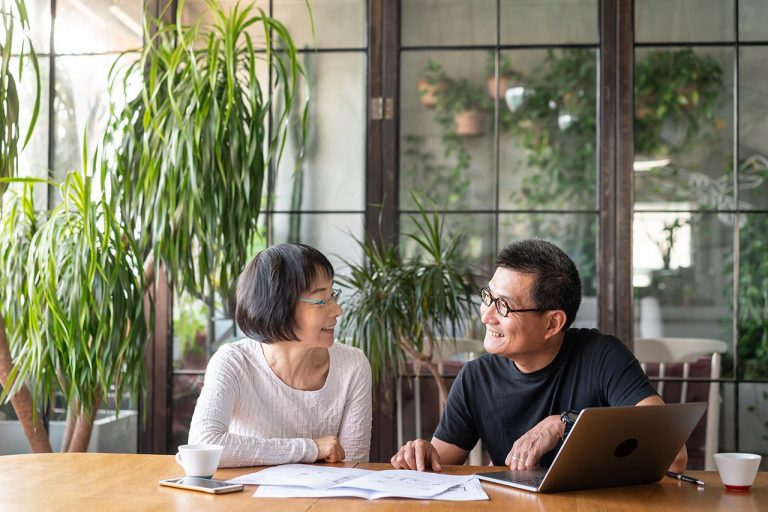 Older couple smiling and reviewing finances