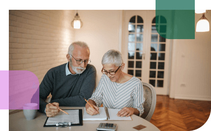 Older man and woman review paperwork together to see if they have enough money to afford the annuity they want to purchase