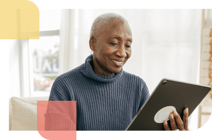 Older African American woman uses her tablet to learn about seniors and annuities, and how they relate to financial literacy