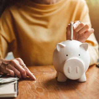 Woman putting money in piggy bank