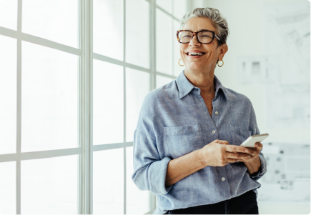 a smiling woman reads about annuities on her phone